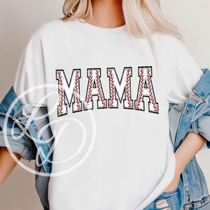 K&ouml;nnte beinhalten: Wei&szlig;es T-Shirt mit dem Wort "MAMA" in roten und schwarzen Buchstaben mit einem Baseball-Stich-Design.