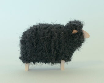 Minimalistic black sheep figurine, from wood and fluffy fleece. Flat face.