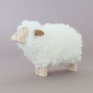 Minimalist sheep figurine, from wood and fluffy wool fleece. Flat face.