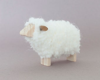 Minimalist sheep figurine, from wood and fluffy wool fleece. Flat face.