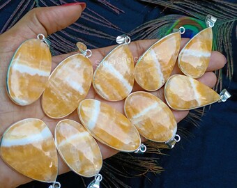 May include: A collection of 10 yellow and white banded agate gemstone pendants with silver bail settings. The pendants are teardrop shaped and have a natural, polished finish.