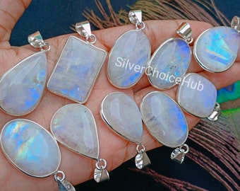May include: A collection of ten silver pendants with rainbow moonstone gemstones. The pendants are in various shapes, including oval, teardrop, and rectangular. The moonstone gemstones have a milky white color with iridescent blue and green flashes.