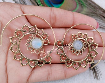 May include: A pair of gold hoop earrings with a spiral design and a white moonstone in the center of each earring.