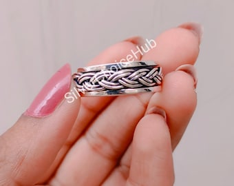May include: A silver braided spinner ring. The ring is made of a braided metal band that spins freely.
