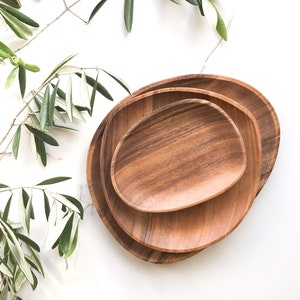 May include: Three wooden serving bowls in a set, nested together. The bowls are oval shaped and have a natural wood grain finish.