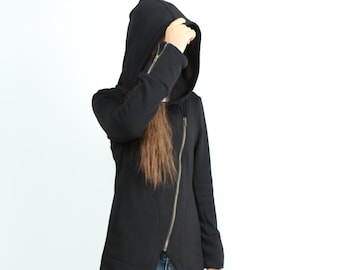 May include: A black hooded sweatshirt with a long asymmetrical hemline and a zipper closure. The sweatshirt has a relaxed fit and is made of a soft, comfortable fabric.