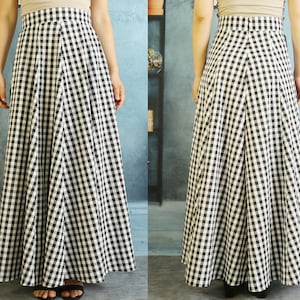 Op de afbeelding: Een zwart-witte gingham maxi-rok met een hoge taille en een volle, vloeiende silhouet.