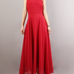 K&ouml;nnte beinhalten: Ein langes, rotes, &auml;rmelloses Maxikleid mit quadratischem Ausschnitt und d&uuml;nnen Tr&auml;gern. Das Kleid hat eine flie&szlig;ende, A-f&ouml;rmige Silhouette.