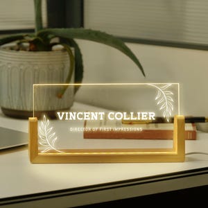 a glass plaque sitting on top of a desk next to a laptop
