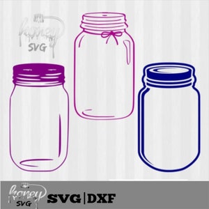 May include: Three empty mason jars, one purple, one blue, and one pink. The jars are all the same size and shape, and they are all empty. The jars are on a white background.