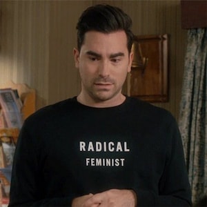 K&ouml;nnte beinhalten: Ein Mann tr&auml;gt ein schwarzes Langarmshirt mit dem Aufdruck "RADICAL FEMINIST" in wei&szlig; auf der Vorderseite.
