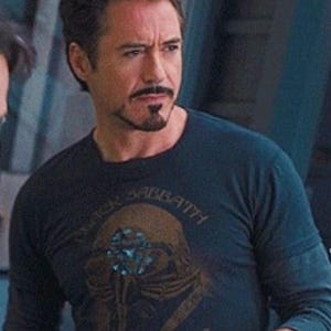 May include: A navy blue long-sleeve shirt featuring a graphic of a skull with the text "BLACK SABBATH". The shirt is worn by a person with dark hair and a goatee.