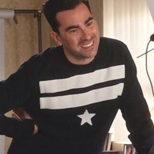 May include: A black long-sleeved shirt with white stripes and a white star on the front.