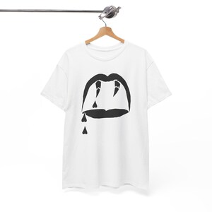 Op de afbeelding: Wit T-shirt met een zwarte afbeelding van een mond met tanden en druppels bloed in de vorm van harten.