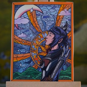 May include: A colorful illustration of a woman with dark blue hair and a horned headpiece, set against a stained-glass style background. The artwork features a crescent moon, stars, and a sun-like design, with an orange border.