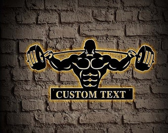 May include: Black metal silhouette of a weightlifter lifting a barbell with yellow accents. The silhouette is on a brick wall background. The text "CUSTOM TEXT" is on a black banner below the silhouette.