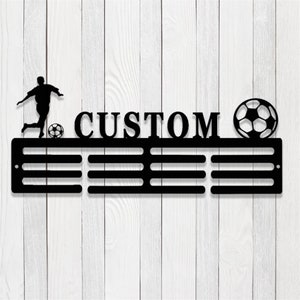May include: Black metal medal display with a silhouette of a football player, a football, and the word "CUSTOM". The display has 8 slots for medals.
