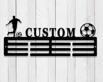 May include: Black metal medal display with a soccer player silhouette, a soccer ball, and the word "CUSTOM". The display has 8 slots for medals.