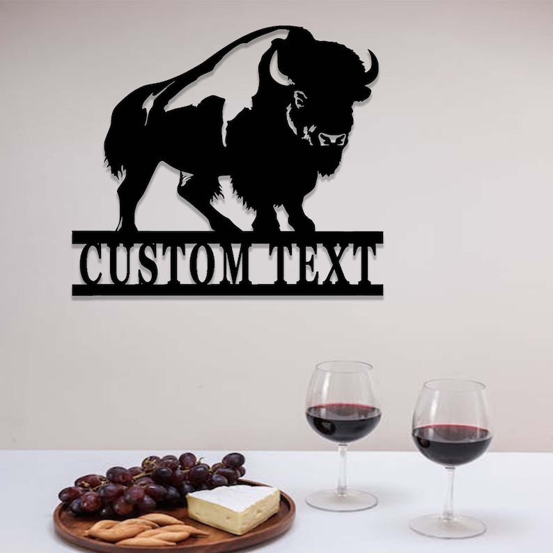K&ouml;nnte beinhalten: Schwarze Metallsilhouette eines Bisons mit einem personalisierten Textbanner darunter. Das Banner lautet "CUSTOM TEXT".
