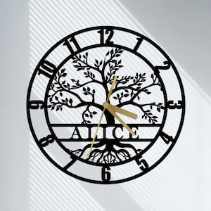 Puede incluir: Reloj de pared de metal negro con un diseño de árbol de la vida y el nombre "Alice" inscrito debajo. El reloj tiene manecillas doradas y marcas de números romanos.