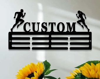 May include: Black metal medal display rack with the word "CUSTOM" in large letters. The rack has 10 slots for medals and features two running figures on either side.