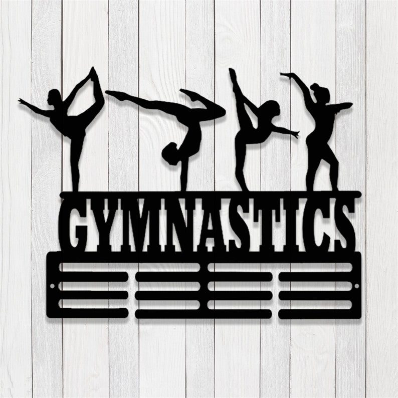 May include: Black metal gymnastics medal holder with four gymnast silhouettes and the word "GYMNASTICS" above a row of medal hooks.