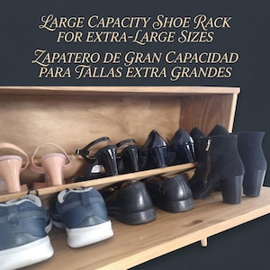 May include: A wooden shoe rack displaying various shoes, including heels, boots, and trainers. The rack has two shelves. The text on the image reads "LARGE CAPACITY SHOE RACK FOR EXTRA-LARGE SIZES". The rack is designed to hold extra-large shoe sizes.