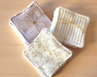 May include: Three sets of reusable makeup remover pads. One set is beige, one is white with a waffle texture, and one is white with a floral pattern. All sets are tied with twine.