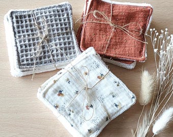 May include: Three sets of reusable makeup remover pads. One set is gray waffle weave, one is brown with gold flecks, and one is white with a floral pattern. All sets are tied with twine.