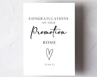 May include: A white card with black text that reads "Congratulations on your Promotion Rosie" with a hand-drawn heart and the date "27.04.22".