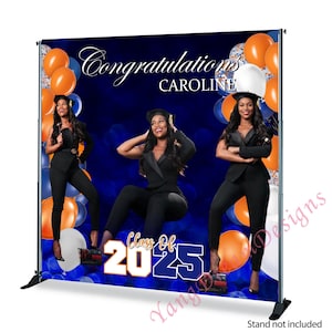 May include: A blue and orange graduation backdrop with the text "Congratulations Caroline" and "Class of 2025". The backdrop features three women in black outfits and balloons.