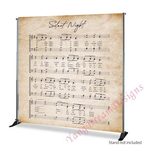 May include: A backdrop featuring the sheet music for "Silent Night" printed on aged paper. The text and musical notes are in black, set against a beige background. The backdrop is supported by a black metal frame.