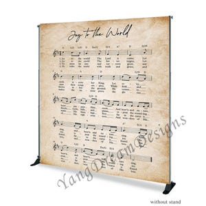 May include: A vintage-style backdrop featuring the lyrics and sheet music for the Christmas carol "Joy to the World". The backdrop is printed on a textured, cream-coloured paper with brown accents. The text is in black.