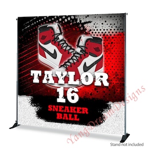 Op de afbeelding: Een rode en zwarte basketball-achtergrond met een paar rode en witte sneakers. De achtergrond heeft een wit en zwart splatterontwerp en de tekst "Taylor 16 Sneaker Ball".