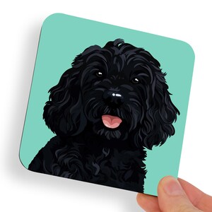 May include: Square coaster featuring a black dog with a fluffy coat and pink tongue, set against a light teal background. The dog's portrait is a detailed illustration, perfect for dog lovers.