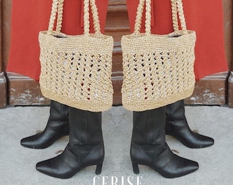 Könnte beinhalten: Zwei beigefarbene Crochet-Tragetaschen mit dicken Seilgriffen. Die Taschen hängen an den Händen einer Person, die einen roten Rock und schwarze Stiefel trägt. Das Wort "CERISE" ist in Weiß auf dem Boden gedruckt.