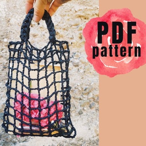 May include: Black crocheted tote bag with a braided handle. The bag is filled with pink flowers and a book. The image includes the text "PDF pattern".