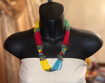 May include: A multi-strand beaded necklace with yellow, red, green, blue and black beads. The necklace is on a black mannequin.