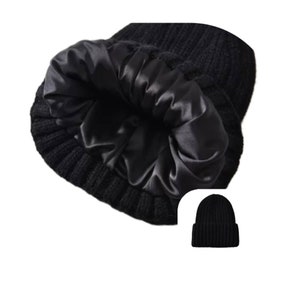May include: Black knitted beanie hat with a satin lining. The hat is shown inside out, revealing the smooth, shiny interior. A smaller image of the hat is shown in the corner.