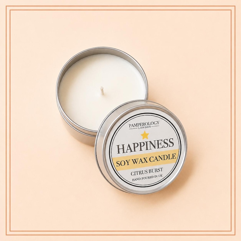 May include: A round silver metal tin containing a white soy wax candle with a single centered wick. The lid is placed beside the tin, featuring a label that reads PAMPEROLOGY LONDON, HAPPINESS, SOY WAX CANDLE, CITRUS BURST, HAND POURED IN UK.