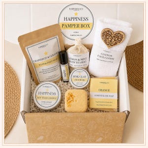 May include: A gift box containing a Grapefruit & Geranium bath soak, a Happy roller oil, a Lemon & Mint bath tea bag, a white cotton face cloth with a wooden heart, a Pink Clay face mask, a Happiness soy candle, and an Orange essential oil soap.