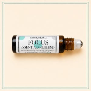 K&ouml;nnte beinhalten: Eine kleine Roll-on-Flasche aus bernsteinfarbenem Glas mit einem wei&szlig;en Etikett, das den Text Pamperology London Focus Essential Oil Blend tr&auml;gt. Das Etikett listet Rosmarin, Grapefruit und Mandarine in Traubenkern&ouml;l auf. Mit wei&szlig;em Roll-on-Aufsatz.