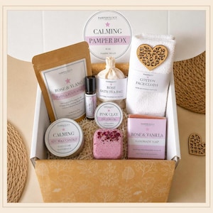 May include: A gift box containing a Pamperology London Calming Pamper Box set with a rose bath and foot soak, a rose bath tea bag, a rollerball, a pink clay face mask, a white cotton face cloth with a heart cutout, a soy candle, and rose soap.