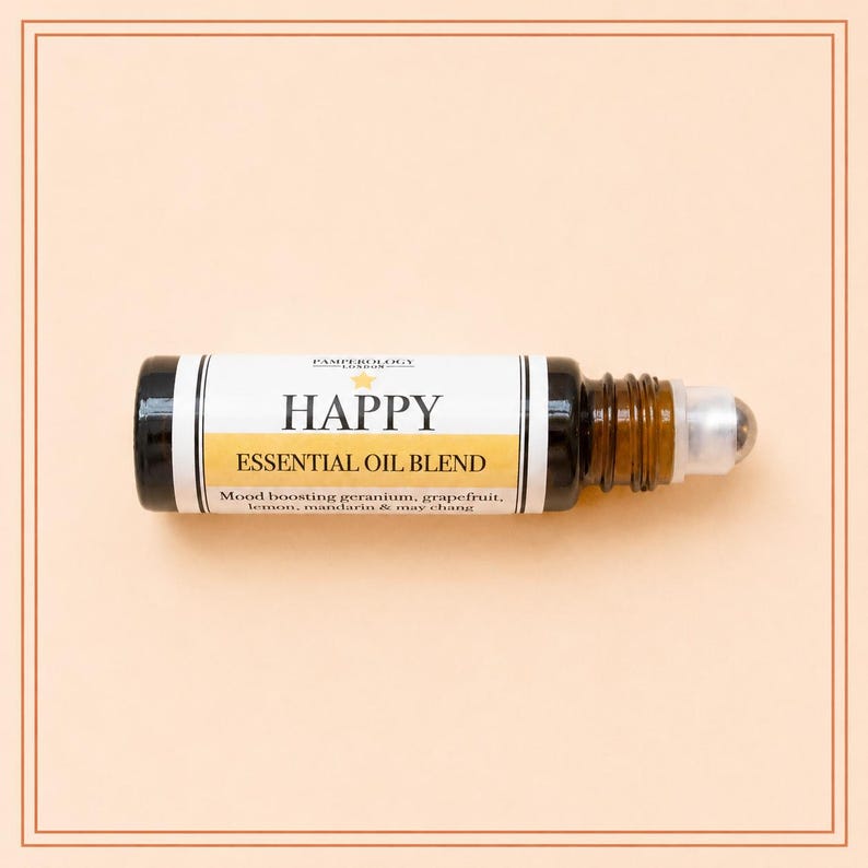 May include: A dark amber glass roller bottle containing an essential oil blend. The white label features the text HAPPY, ESSENTIAL OIL BLEND, and lists ingredients including geranium, grapefruit, lemon, mandarin, and may chang.