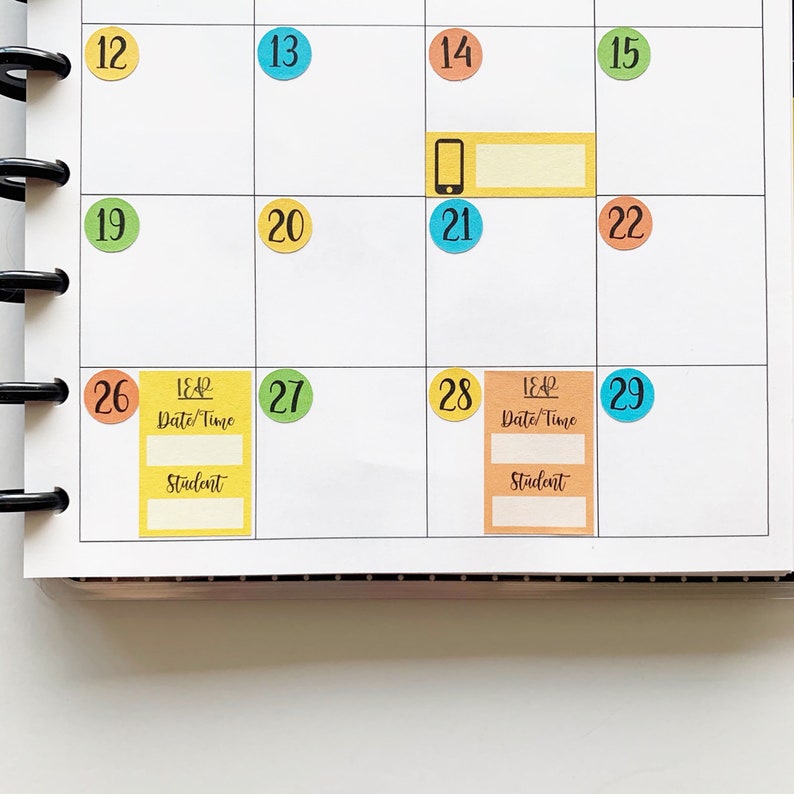 May include: A monthly calendar with colorful stickers for each day. The stickers have numbers on them, and some have additional text, such as "LEAR Date/Time" and "Student".
