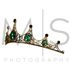 May include: A gold crown with green and clear gemstones. The crown is on a white background with the text "MS PHOTOGRAPHY" below it.