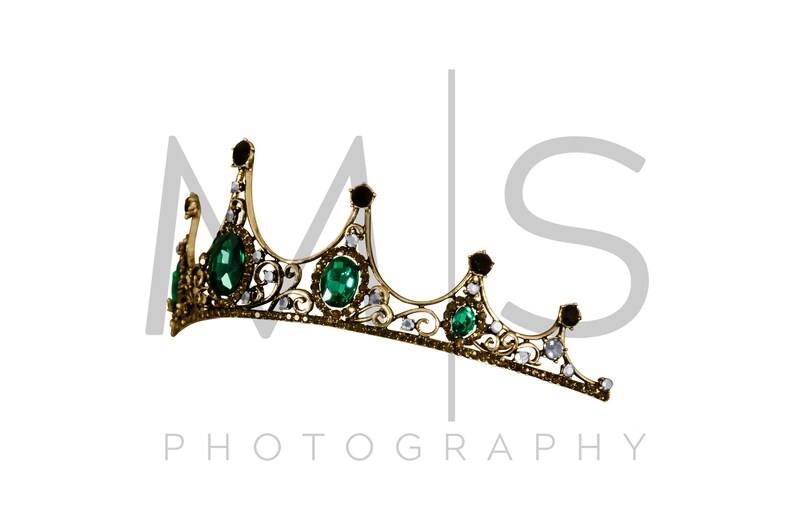 May include: A gold crown with green and clear gemstones. The crown is on a white background with the text "MS PHOTOGRAPHY" below it.