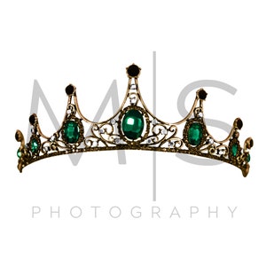 May include: A gold crown with green gemstones and clear rhinestones. The crown has a delicate, ornate design.