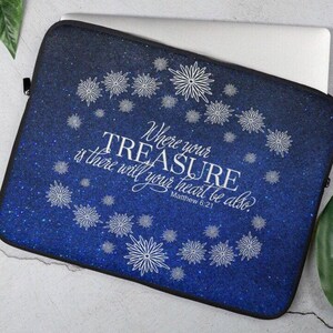 May include: Blue laptop sleeve with a glittery finish and white snowflakes. The text "Where your treasure is there will your heart be also. Matthew 6:21" is printed on the sleeve.