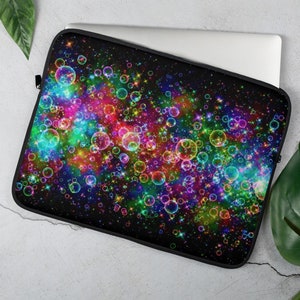 Puede incluir: Una funda para portátil negra con un diseño colorido de burbujas arcoíris y estrellas sobre un fondo negro.